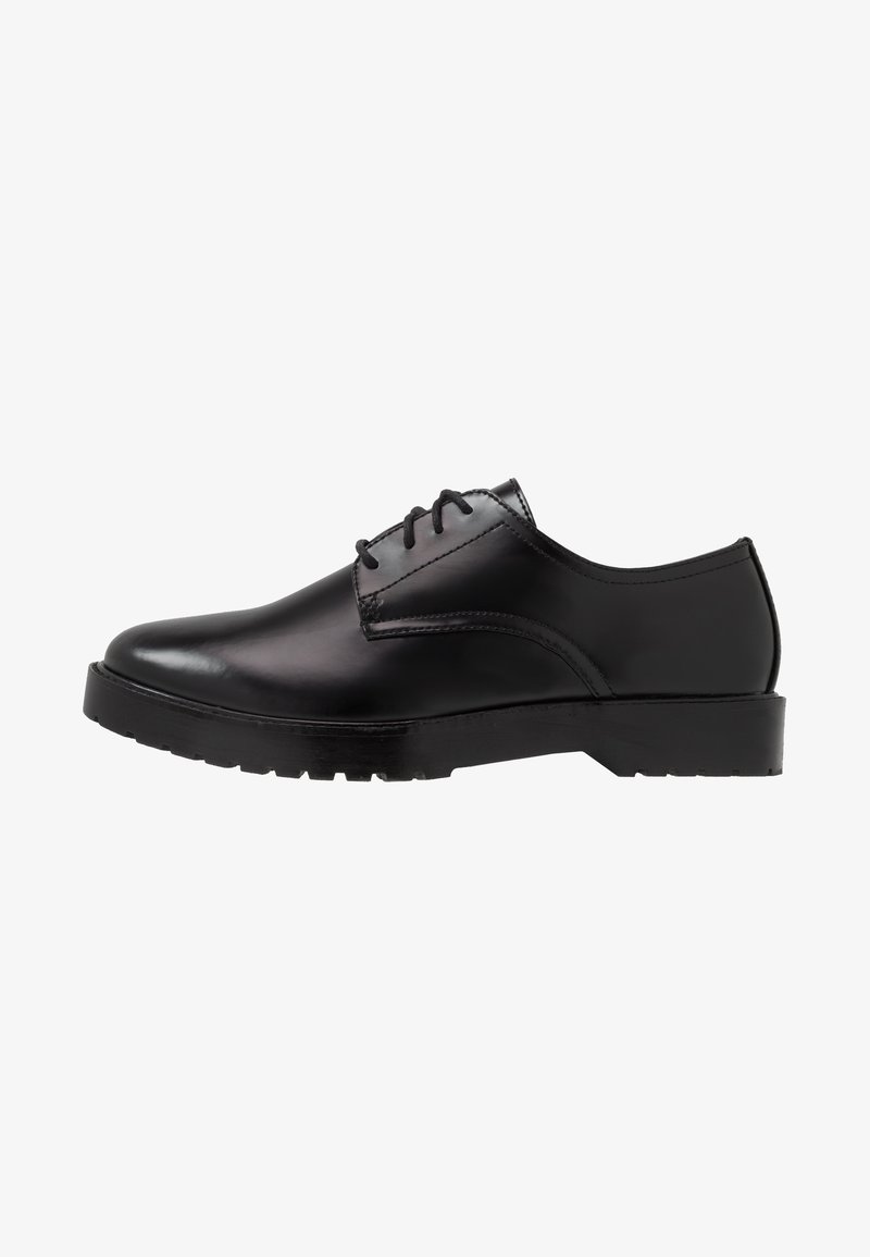 Chaussure habillée Oxford en cuir noir à lacets, semelle épaisse et bout rond lisse, vue de profil.