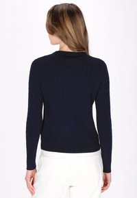 Maglione lavorato a maglia di colore blu navy con motivo a trecce, con polsini e orlo a costine. Vestibilità slim, collo tondo e maniche lunghe. Realizzato in tessuto morbido.