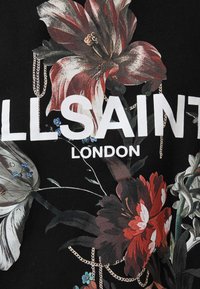 Fekete anyag élénk virágmintával piros, fehér és kék színekkel, lánc részletekkel. Nagy fehér betűkkel olvasható, hogy "ALLSAINT LONDON."