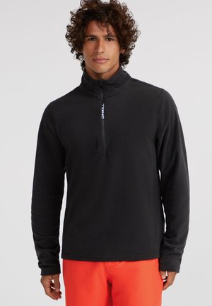 Black fleece pullover with a quarter-zip collar, long sleeves, and a logo detail. Smooth texture, fitted design, and casual style.