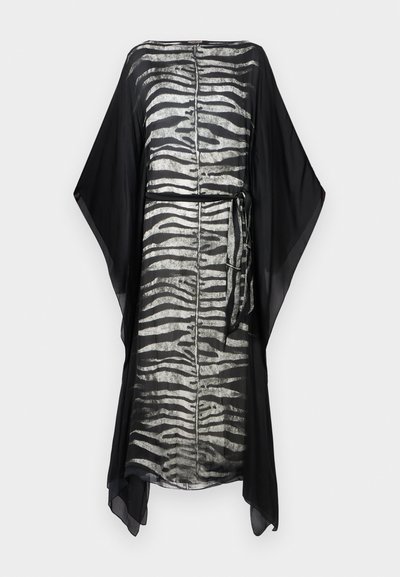 Kaftan negru cu un model de dungi de zebre argintii, material ușor, mâneci largi și detalii cu talie legată. Design simplu și fluid.