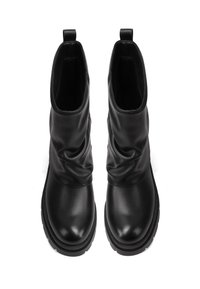 Botas de tobillo negras de cuero con un diseño arrugado, punta redondeada y suela de goma texturizada. Presentan tiradores para facilitar su puesta.