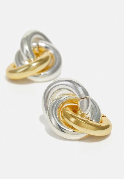 Metallohrringe mit einem Design aus verdrehten Knoten. Silber- und Goldoberflächen mit einer glatten Textur und organischen Formen erzeugen visuelles Interesse.