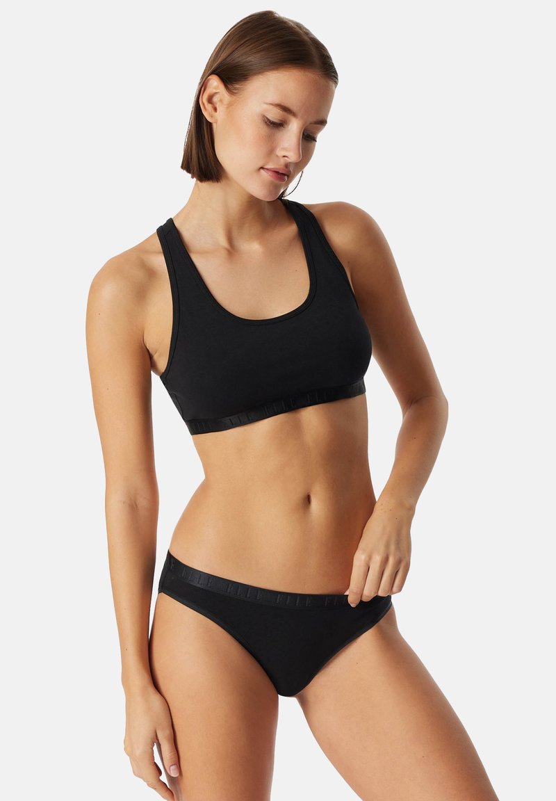 Svart sport-bh och matchande bikiniunderdelar i mjukt tyg. Har ett brett elastiskt band och en enkel, sömlös design.