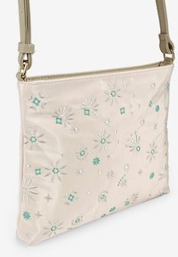 Borsa a spalla satinata chiara con ricami floreali in argento e teal, caratterizzata da un design piatto e tracolla regolabile.