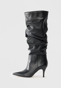 Black leather knee-high boots with a slouchy design, pointed toe, and a slender stiletto heel. Smooth texture, minimal hardware.