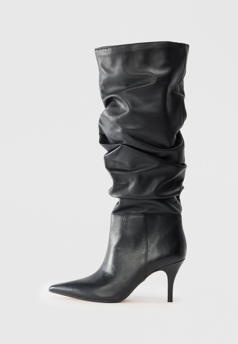 Botas altas de cuero negro con un diseño caído, puntera puntiaguda y un elegante tacón de aguja. Textura suave, con un hardware mínimo.