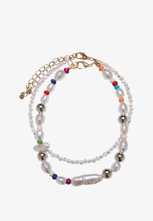 Monivärinen helmet-kaulaketju, jossa on helmiä, hopea- ja kultasävyjä. Kaulaketjussa on pyöreitä, soikeita ja pisaramaisia muotoja kerroksittain.
