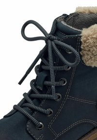Bottes à lacets bleu foncé avec un col en fausse fourrure. Comprend des coutures grises, des œillets ronds et des lacets texturés. Le matériau supérieur semble ressemblant au suède.