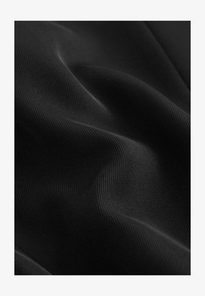 Sort stof med en glat, tekstureret overflade og let glans. Viser subtile folder, der fremhæver dens fleksible og elastiske natur.