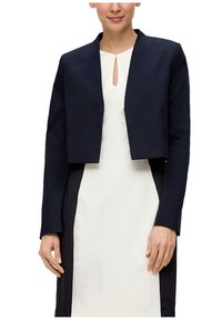 Marineblauwe cropped blazer met een mandarin collar, textiel met structuur en lange mouwen, gecombineerd met een crèmekleurige jurk met een keyhole halslijn.