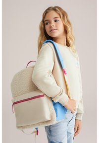 Ryggsäck med en beige texturerad tyg, rosa dragkedja och kontrasterande blå detaljer; justerbara remmar i blått och gult. Avslappnad passform tröja.