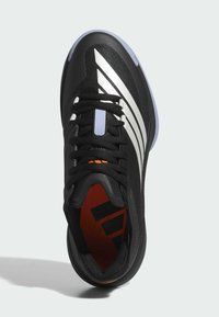 Scarpa sportiva nera con tomaia in rete, strisce argentate e lacci neri. Presenta una soletta arancione e una suola in gomma testurizzata.