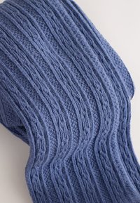 Neulottu sininen huivi, jossa on kuvioitu pinta pystyviivoilla ja uurteilla, pehmeä kangas ja hieman väljä kudonta.