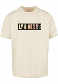 Krème farvet bomulds t-shirt med en rektangulær grafik, der står "LAS VEGAS" i forskellige farver mod en sort baggrund.