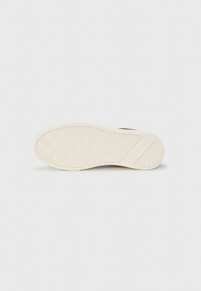 Rubber shoe sole in cream with a textured pattern featuring swirls. Designed with raised branding on the side for grip and durability.