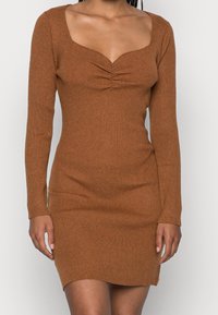 Vestido marrón de manga larga con canalé y silueta ajustada, escote cuadrado y detalles fruncidos en la parte delantera. Material suave, longitud hasta la mitad del muslo.