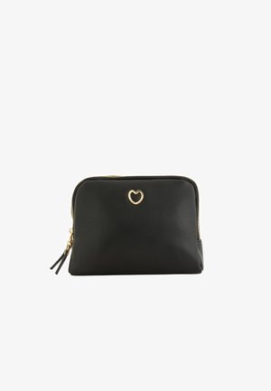 Pochette texturée noire avec emblème en forme de cœur doré et double fermeture éclair avec tirettes en cuir noir sur fond blanc.