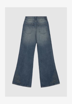 Jeans larghi in denim blu con effetto sbiadito, caratterizzati da due tasche posteriori e cuciture decorative sull'orlo inferiore a motivo a spirale.