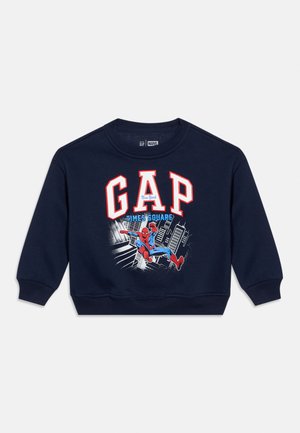 Marineblauwe sweatshirt met witte en rode "GAP"-tekst, afbeelding van Spider-Man en een stadsgezicht. Geribbelde manchetten en zoom, zachte stoftextuur.