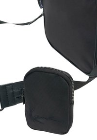 Czarna torebka crossbody z gładką fakturą, z dołączoną zasuwaną kieszonką na pasku oraz subtelnym logo marki wyszytym na torebce.