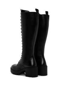 Botas de cuero negro hasta la rodilla con tacón bloque, detalle texturizado y cierre de cremallera lateral, adornadas con tachuelas decorativas en el lado exterior.