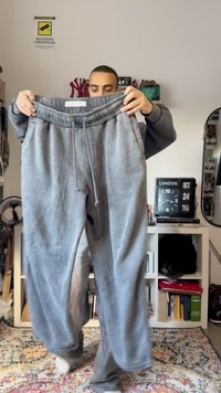 Grå sweatpants med elastisk midjeband och dragsko. Mjuk textur, lös passform och lättblekt design. Passar för vardagsbruk.