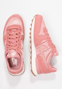 Růžové sportovní boty s kombinací saténového a semišového materiálu, s texturovaným designem, kulatými tkaničkami a gumovou podrážkou.