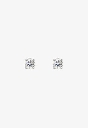 Pendientes de studs de cristal claro y redondo, montados en metal de tono plateado; cuentan con cuatro garras, superficie facetada y un sutil destello con un diseño clásico.