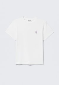 T-shirt en coton blanc avec un petit motif d'ours violet sur le côté gauche de la poitrine ; col rond classique et manches courtes.