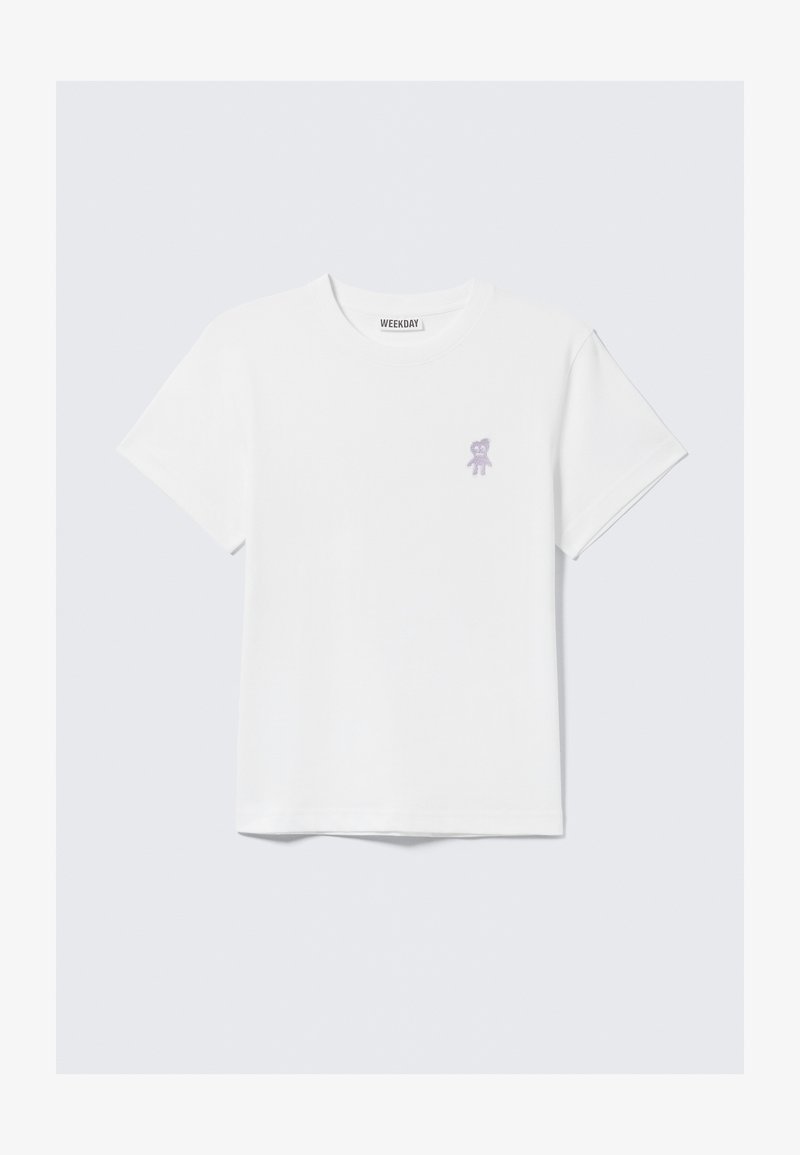 T-shirt en coton blanc avec un petit motif d'ours violet sur le côté gauche de la poitrine ; col rond classique et manches courtes.