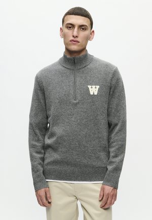 Gray pullover sweater with a high collar, front zipper, and ribbed cuffs. Features a contrasting cream logo on the chest. Soft, textured fabric.