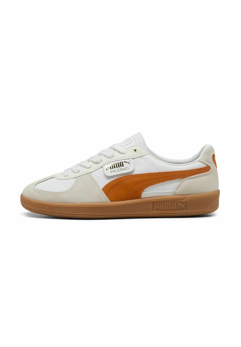Hvide sneakers med orange ruskindsdetaljer, der har en gummisål, stikninger og et PUMA-logo på sidepanelet.
