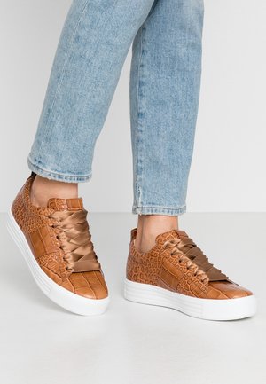 Baskets en simili cuir marron avec un motif crocodile texturé, des lacets en satin, et des semelles en caoutchouc blanches. Style décontracté avec une silhouette basse.