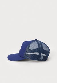 Blå cap med solid frontpanel og mesh bakside. Bøyd skygge, justerbar stropp, med subtile logo detaljer på fronten.