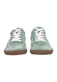 Grüne Wildleder-Sneaker mit weißen Schnürsenkeln, die ein einzigartiges Muster an der Seite und eine strukturierte braune Gummisohle aufweisen.