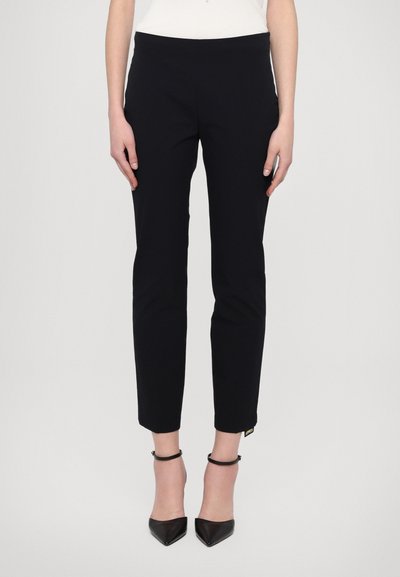Pantalon skinny navy à la texture lisse, coupe ajustée, ourlet à la cheville et petite étiquette de marque sur le côté. Assorti à des escarpins noirs.