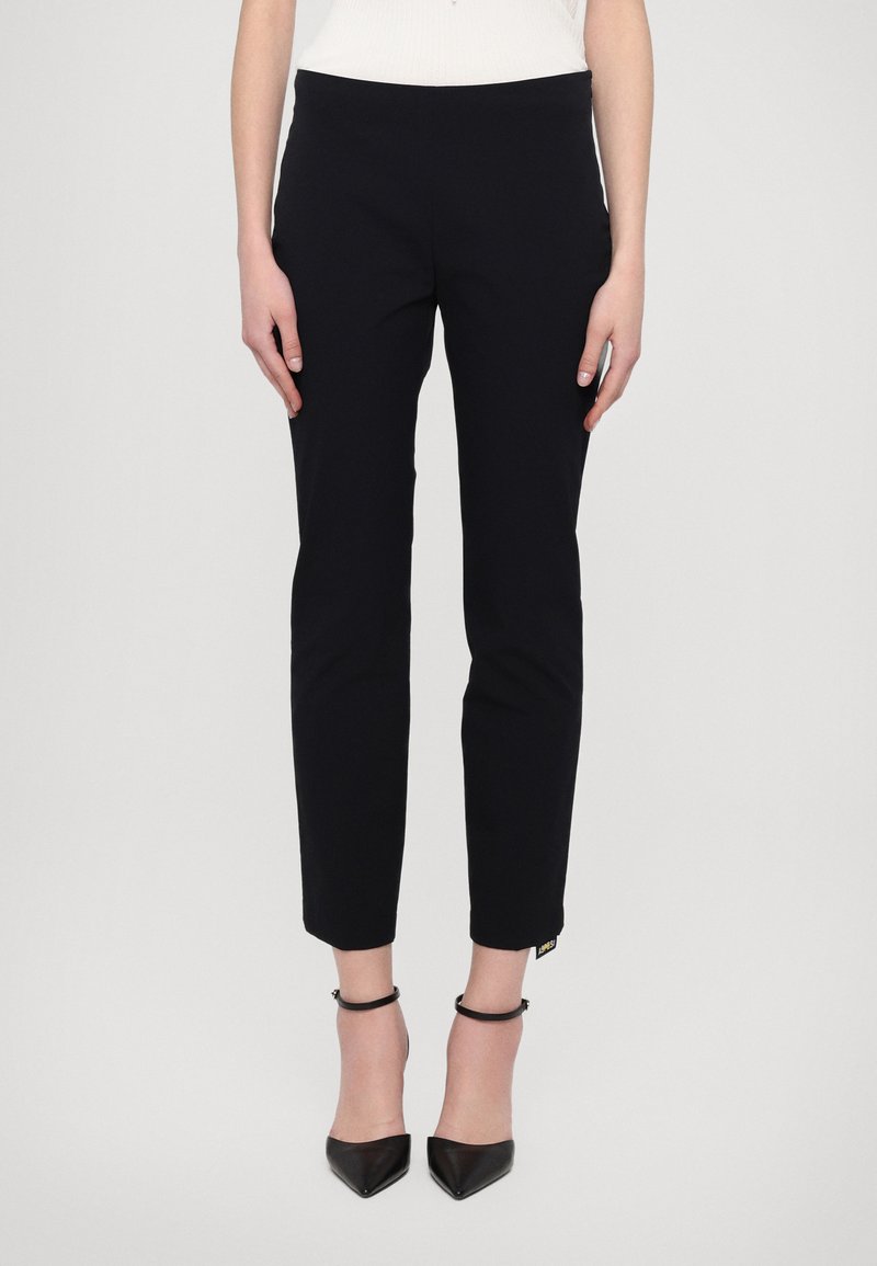 Pantaloni skinny bleumarin cu o textură netedă, croi ajustat, hem la gleznă și un mic eticheta de marcă pe lateral. Purtați cu pantofi cu toc negri.