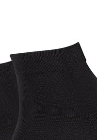 Sorte ankelstr�ømper med en glat tekstur, ribbet manchet og en tætsiddende pasform. Stoffet virker elastisk og holdbart.