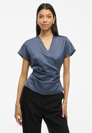 Haut à manches courtes en satin bleu marine avec décolleté en V. Caractérisé par un design drapé avec des plis à la taille, créant une silhouette ajustée.