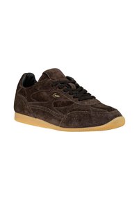 Sneaker in suede marrone con chiusura in pizzo nera, pannelli laterali testurizzati e suola in gomma color gomma. Presenta un marchio sottile sulla linguetta.