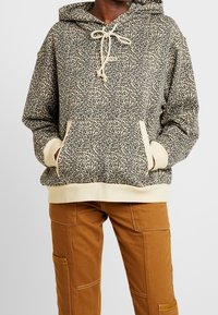 Sudadera con capucha de estampado de leopardo con cordón, puños y dobladillo beige, con un bolsillo delantero. Combina con pantalones cargo marrones.