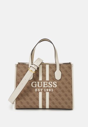 Sac à main Guess marron avec poignées et bandoulière beige, présentant un motif logo et le texte "GUESS EST 1981" sur le devant avec deux bandes beiges verticales.
