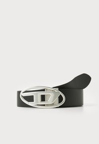 Black rubber belt featuring a large oval silver buckle with an abstract cutout design. Smooth texture, simple and modern shape.