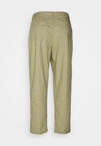 Licht khaki broek met een relaxte pasvorm, gemaakt van een gladde, lichte stof. Bevat twee achterzakken en een eenvoudige tailleband.