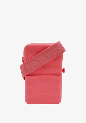 Borsa in silicone rosa con superficie testurizzata e ampia tracolla che presenta il logo "havaianas". Forma rettangolare compatta con chiusura a zip.