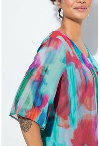 Blusa leggera e trasparente con un motivo astratto multicolore nelle tonalità di blu, rosa e verde. Presenta maniche corte e una scollatura a V.