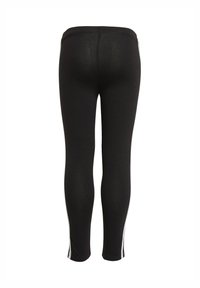 Leggings neri realizzati in tessuto elasticizzato, con strisce laterali bianche. Il design è aderente con una superficie liscia e una vita a media altezza.