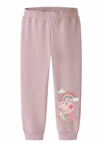 Gaiši rozā sporta bikses ar elastīgu jostu. Rotā komiska cūciņas tēls ar saldējuma kūku zem varavīksnes attēla.