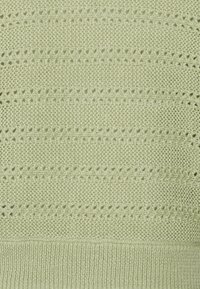 Hellgrüner gestrickter Pullover mit einem strukturierten Muster, das abwechselnde Reihen von offenen und geschlossenen Maschen sowie einen gerippten Saum aufweist.